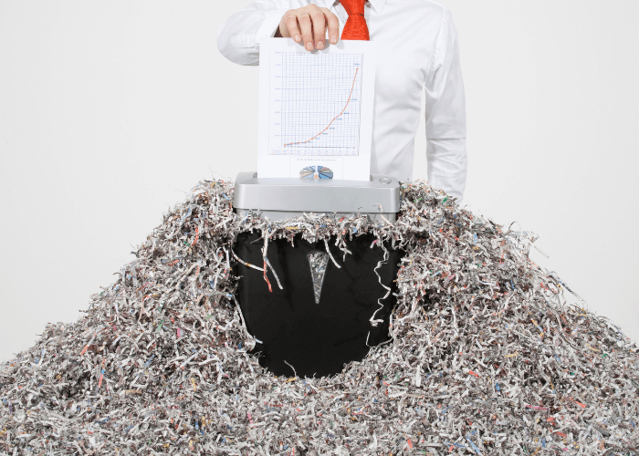 documents being destroyed into pile of shredded paper